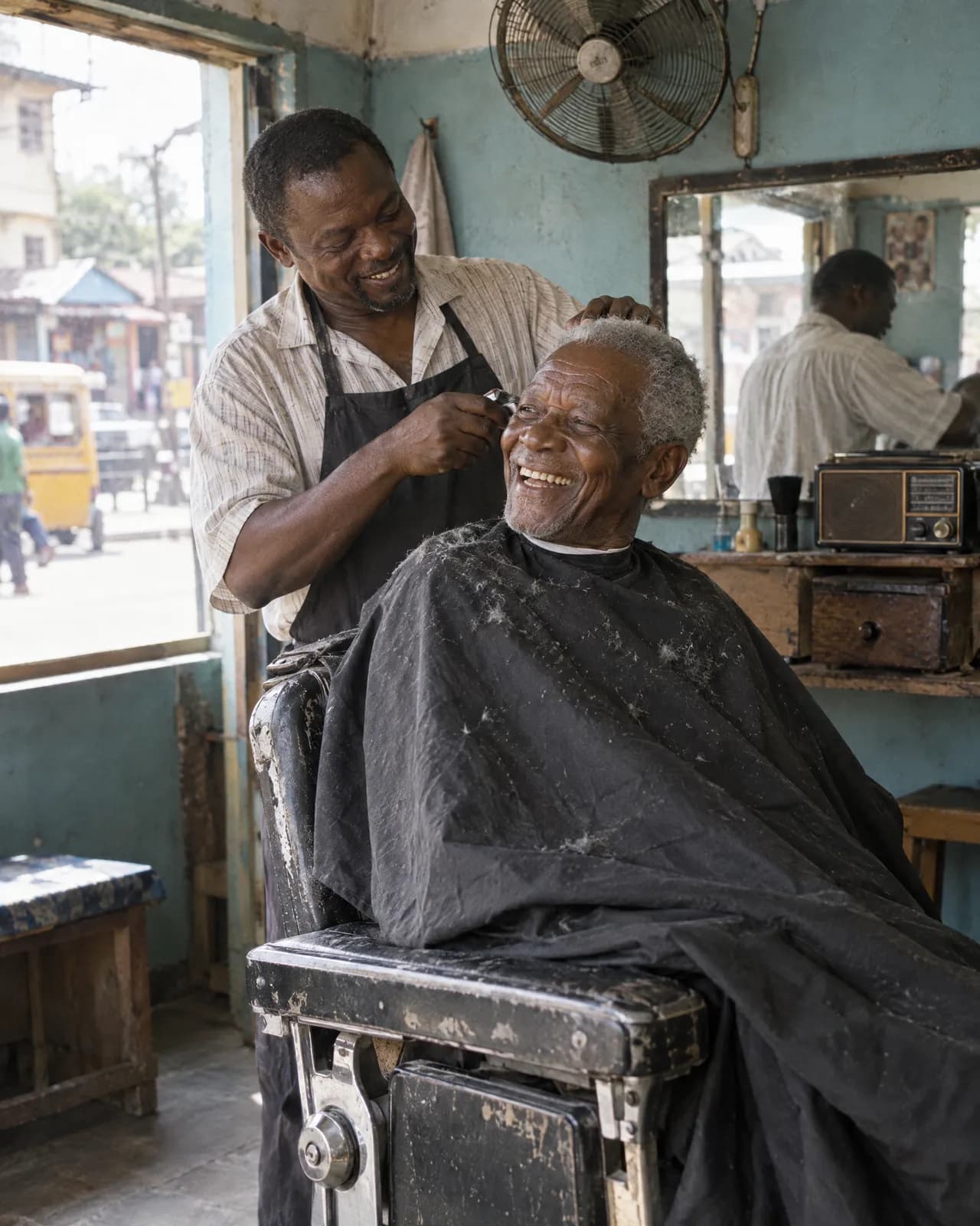 An older man laughing with his barber